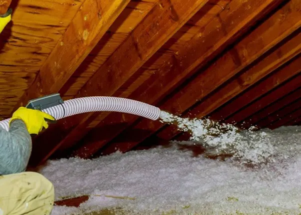 Spray foam insulation between roof rafters in an attic